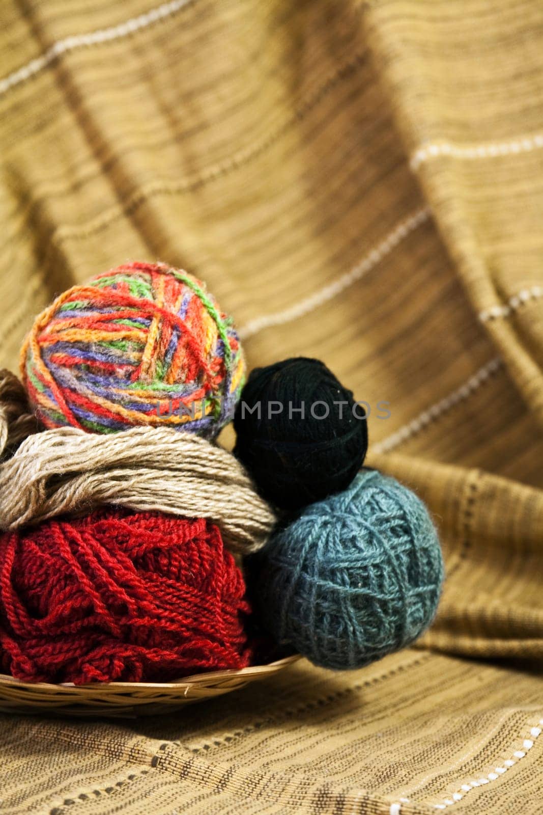 Balls of colored yarn for hand knitting in a decorative basket