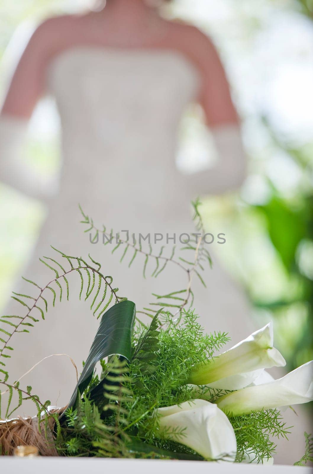 wedding bouquet in foreground, bride in background