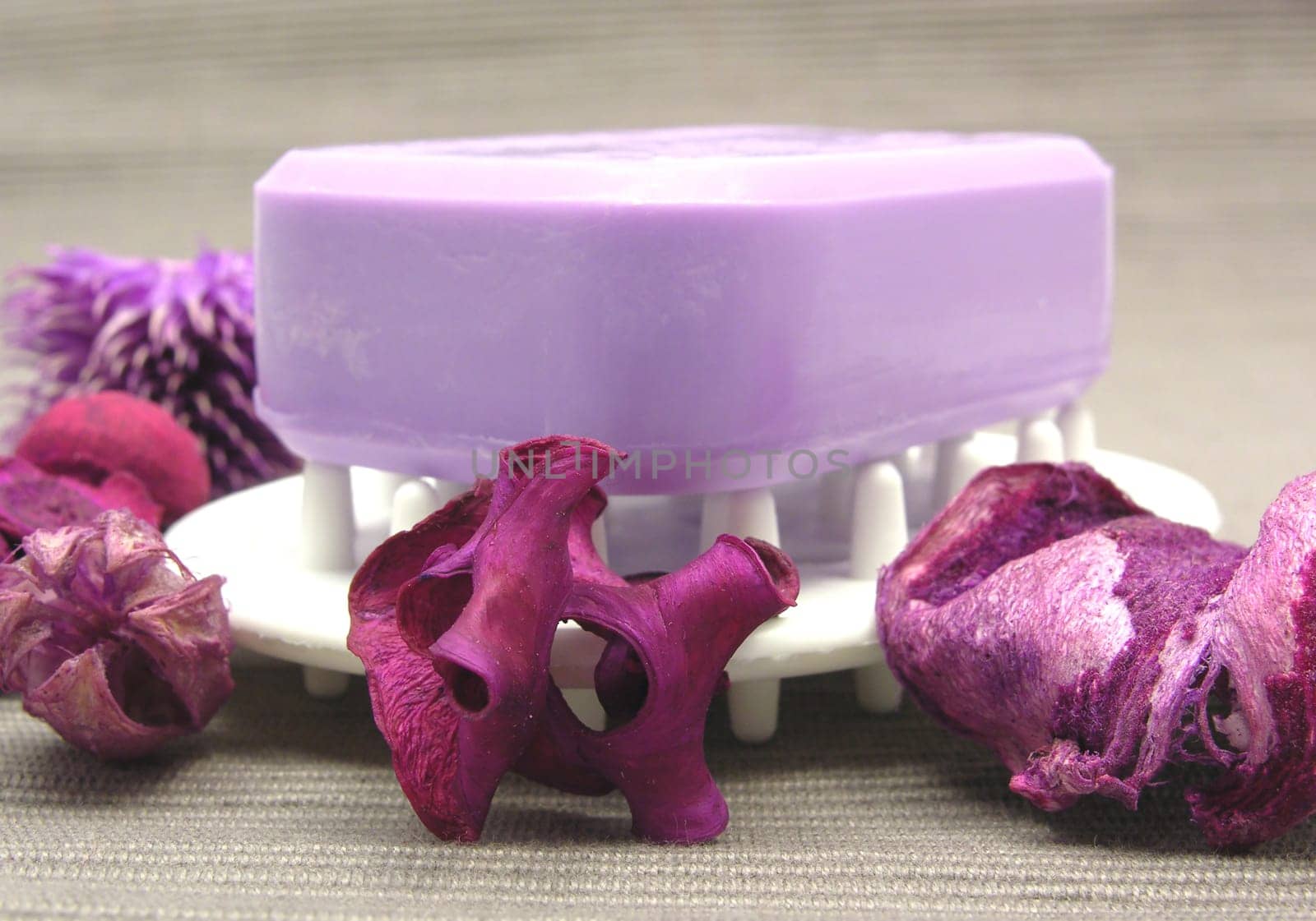 Purple soap with decorative items against gray background
