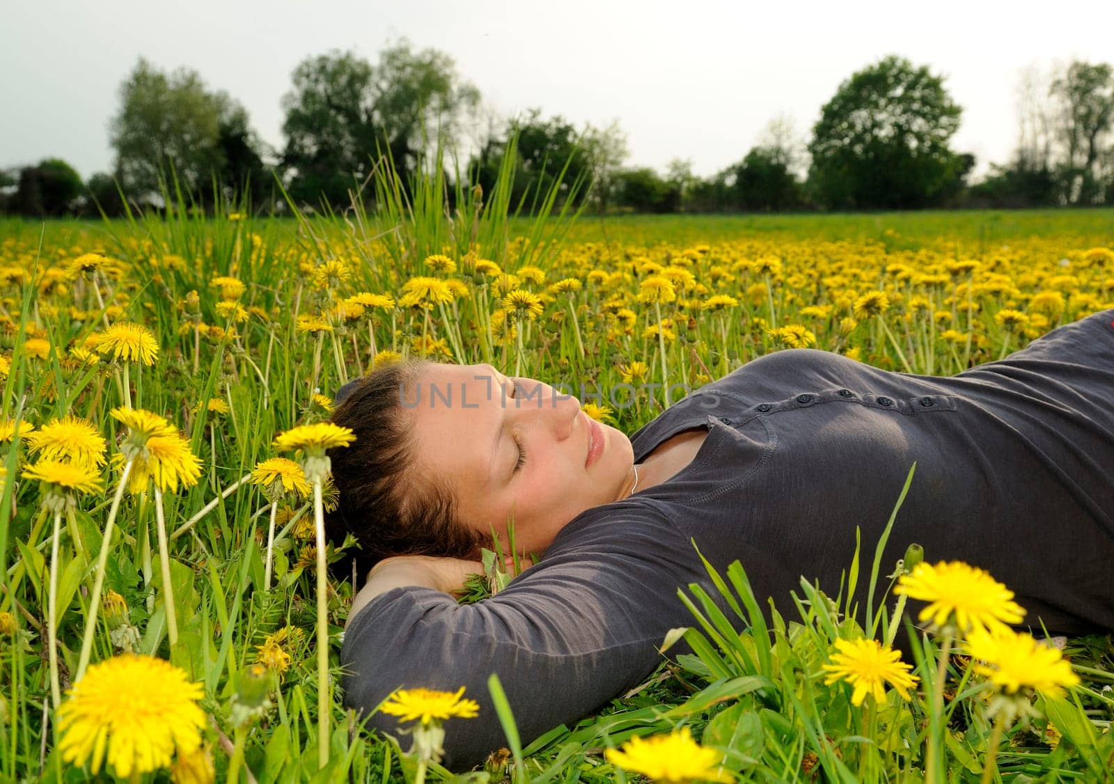 Young woman lying on a flower meadow