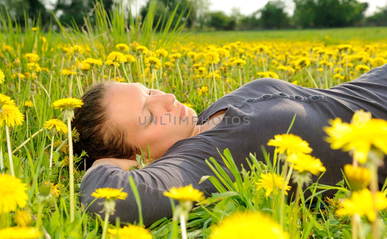 Young woman lying on a flower meadow