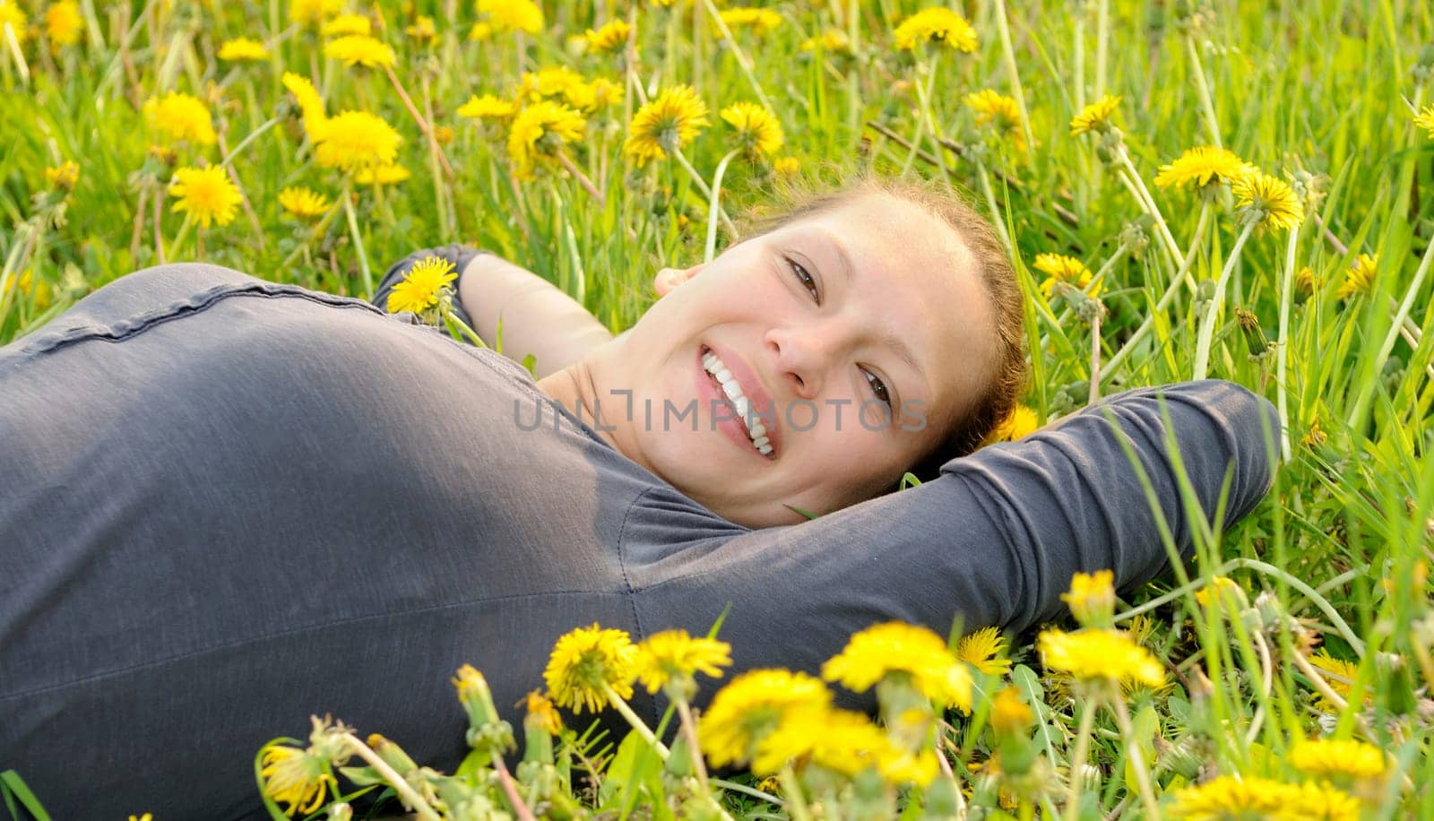 Young woman lying on a flower meadow