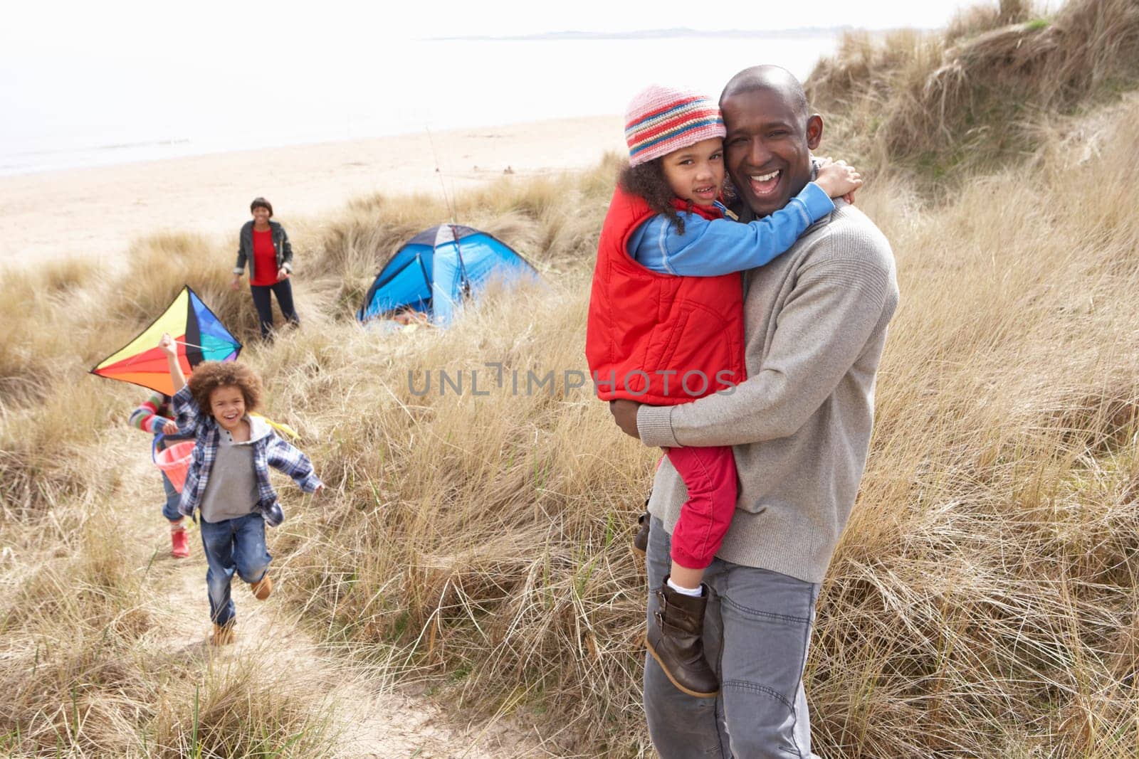 Family Having Fun With Kite In Sand Dunes