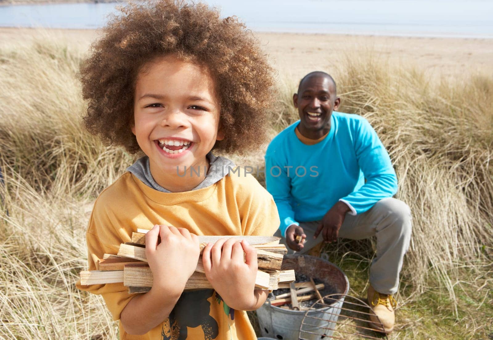 Father And Son Collecting Firewood On Beach Camping Holiday