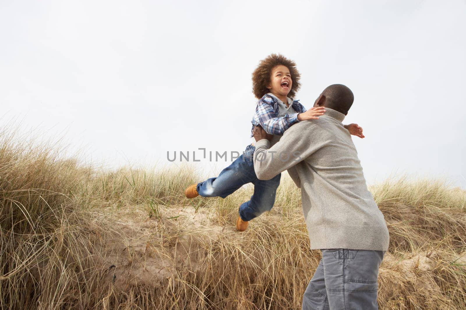 Father And Son Having Fun In Sand Dunes