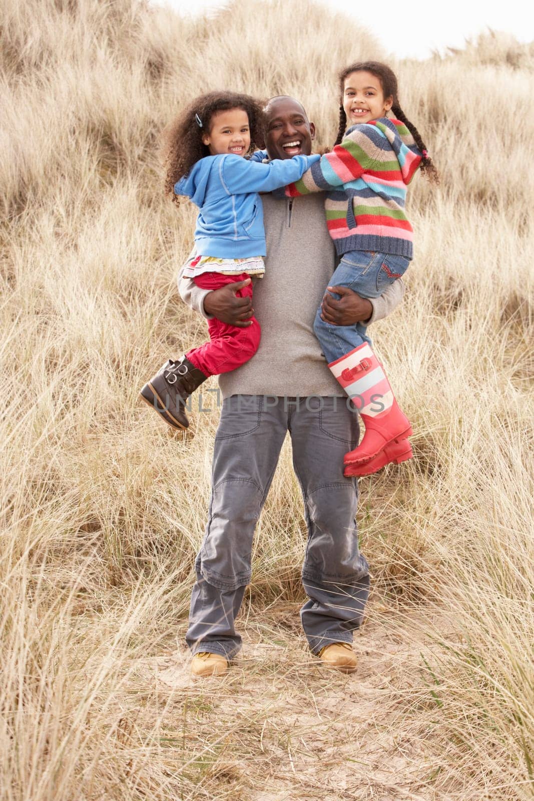 Father And Daughters Having Fun In Sand Dunes