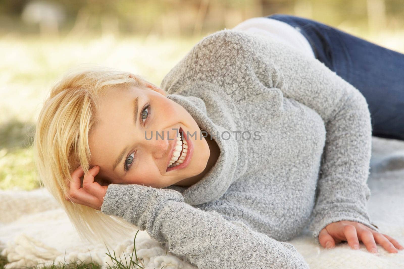 Portrait Of Attractive Young Woman Relaxing On Grass