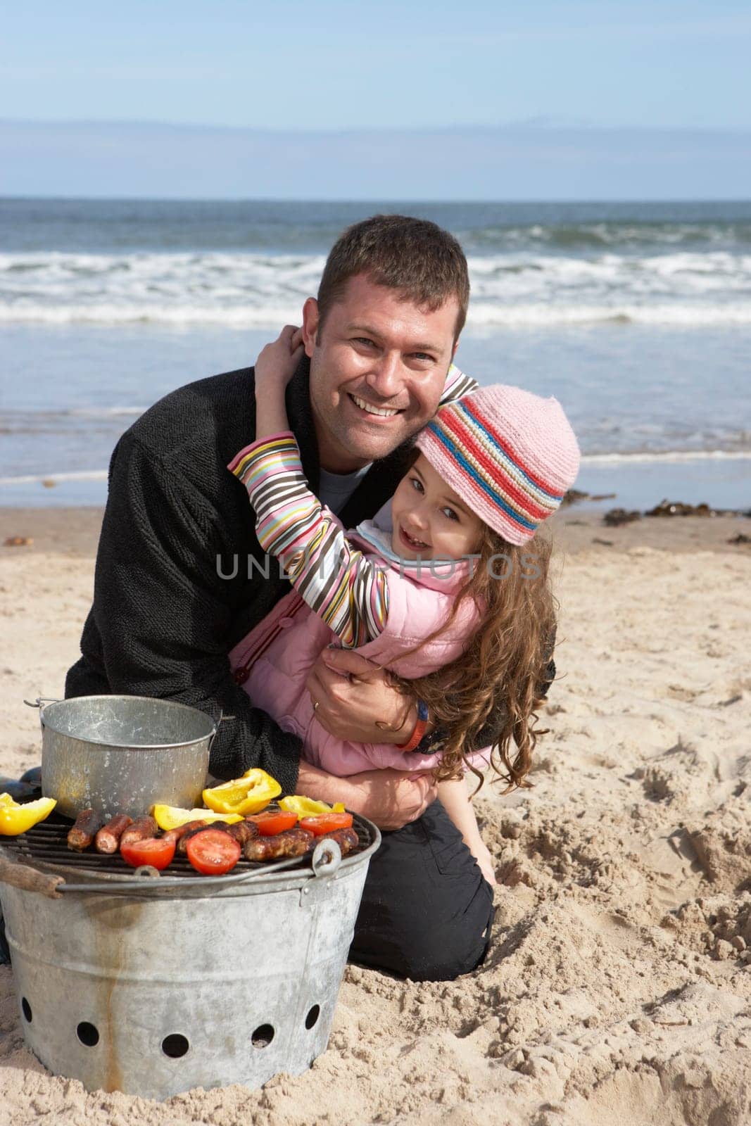 Father And Daughter Having Barbeque On Winter Beach