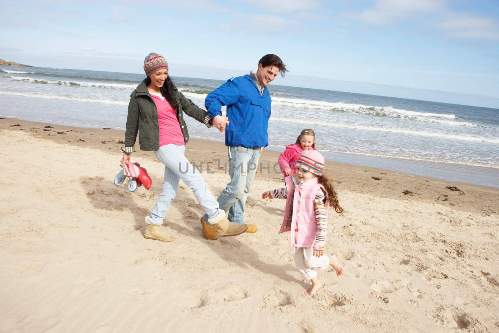 Family Walking Along Winter Beach