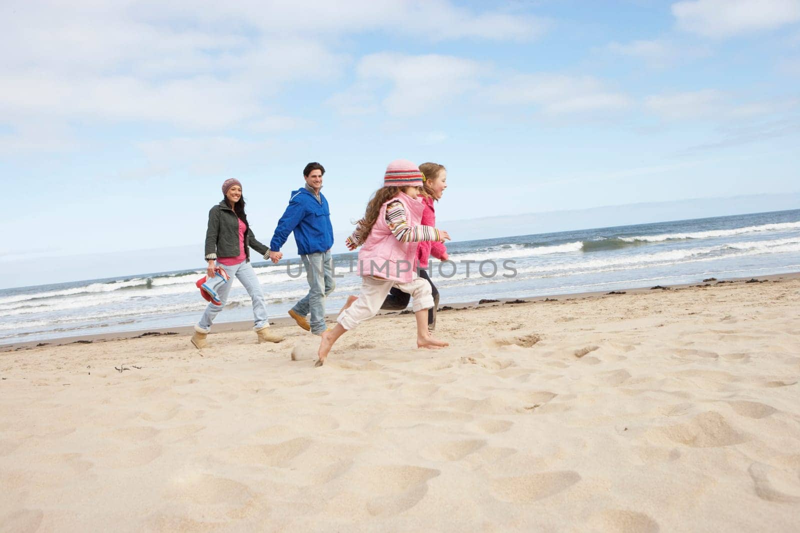 Family Walking Along Winter Beach