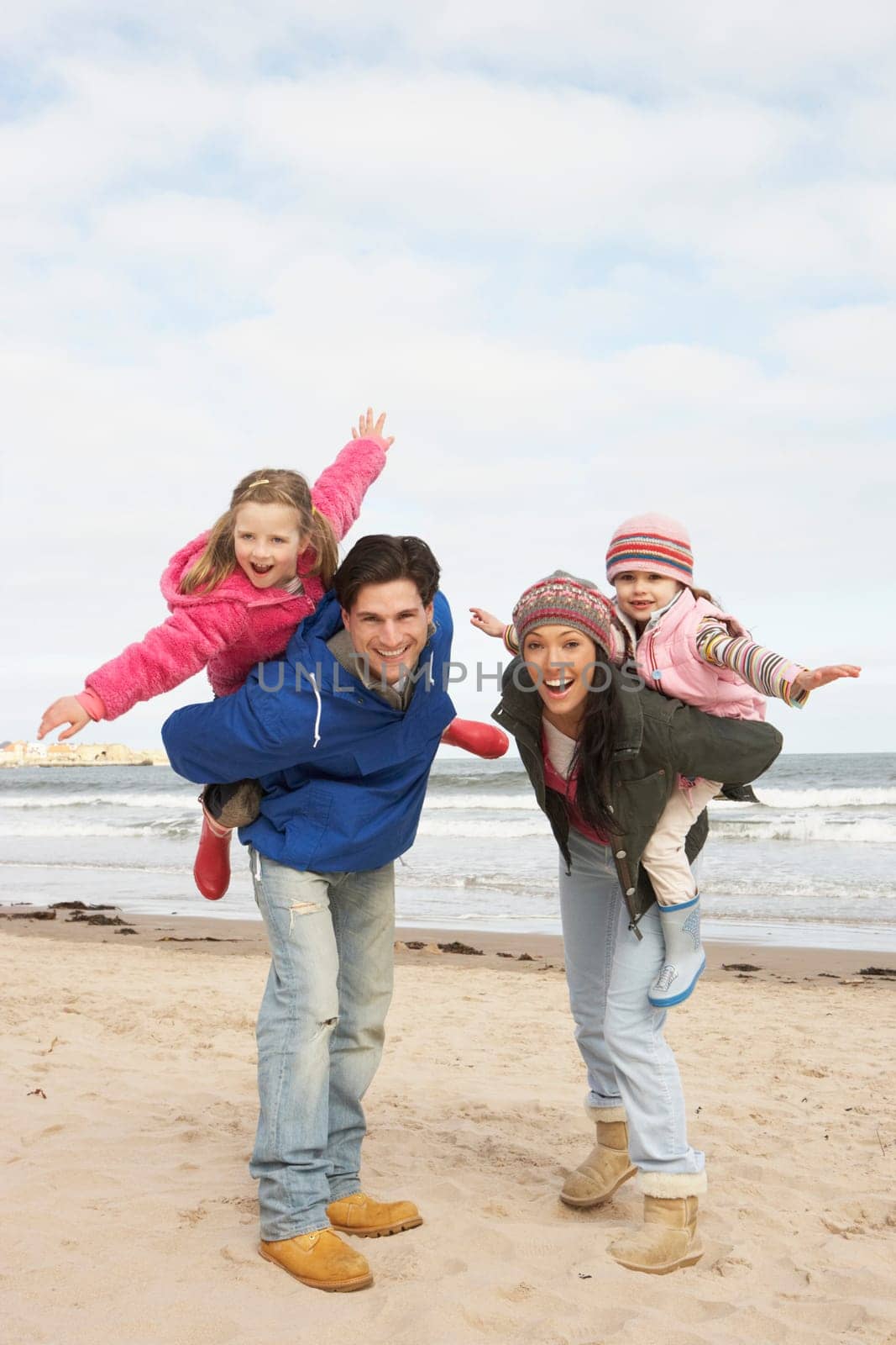 Family Walking Along Winter Beach