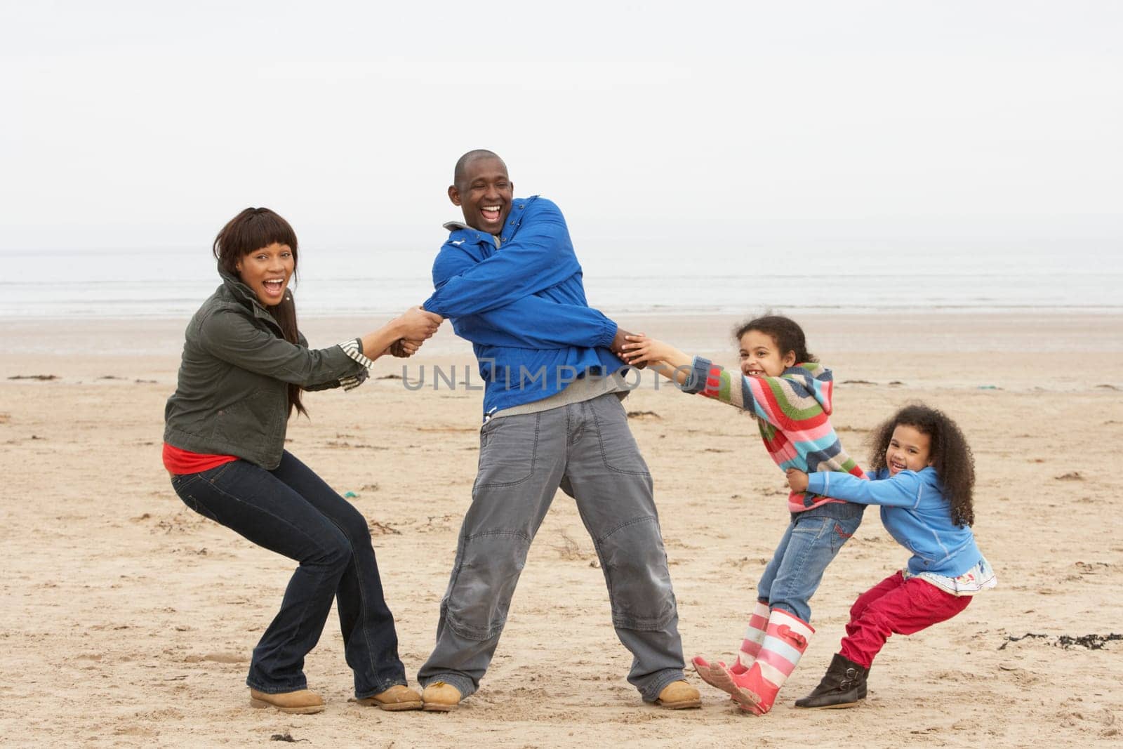 Family Having Fun On Winter Beach
