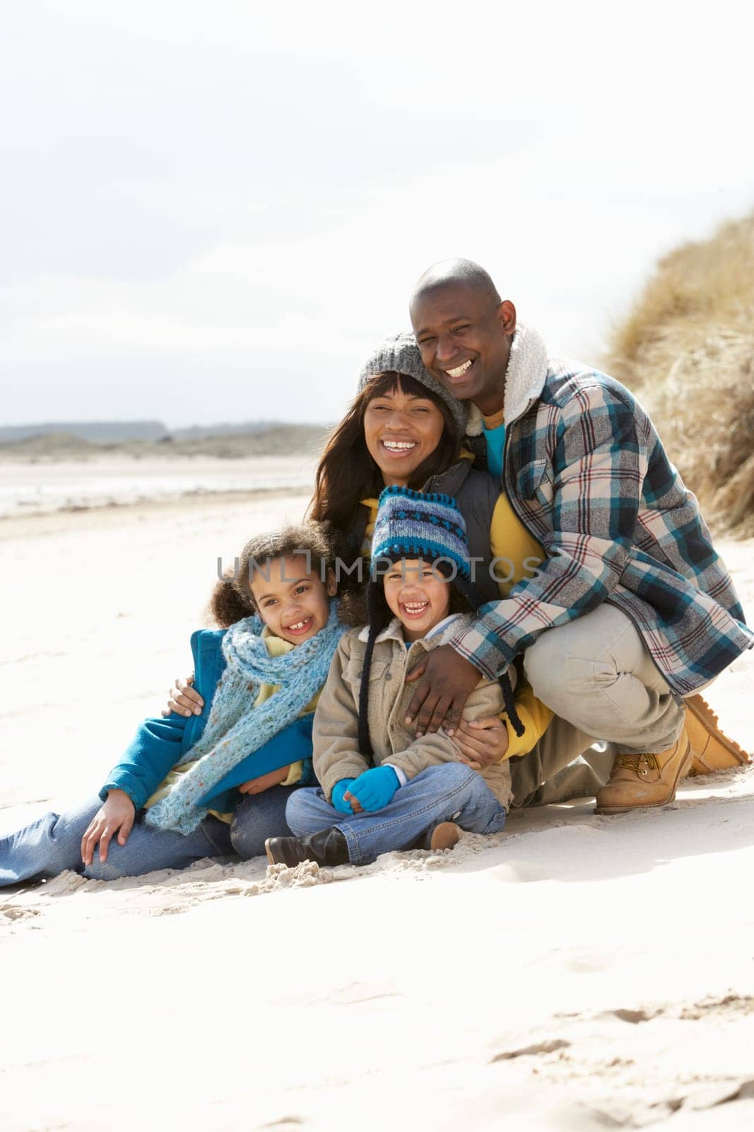 Family Sitting On Winter Beach