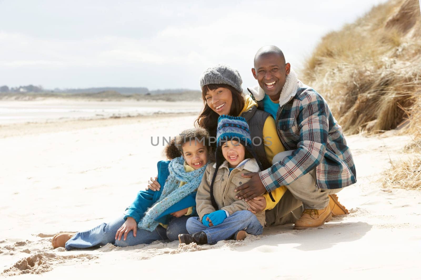 Family Sitting On Winter Beach