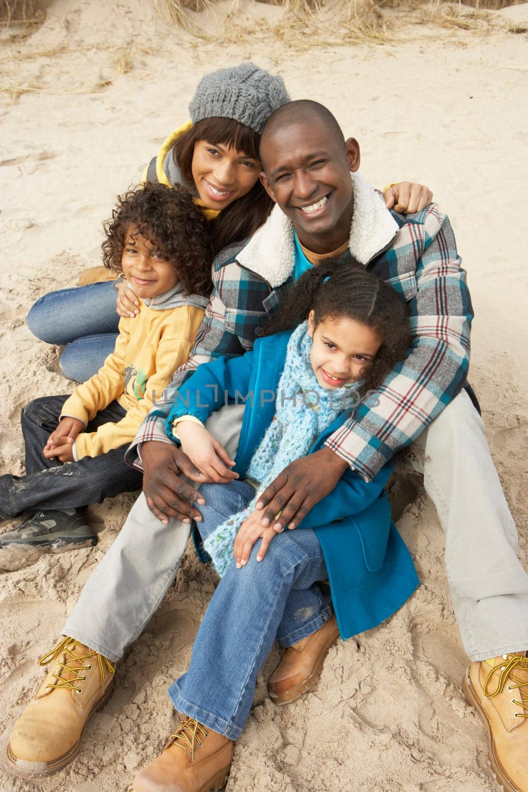 Family Sitting On Winter Beach