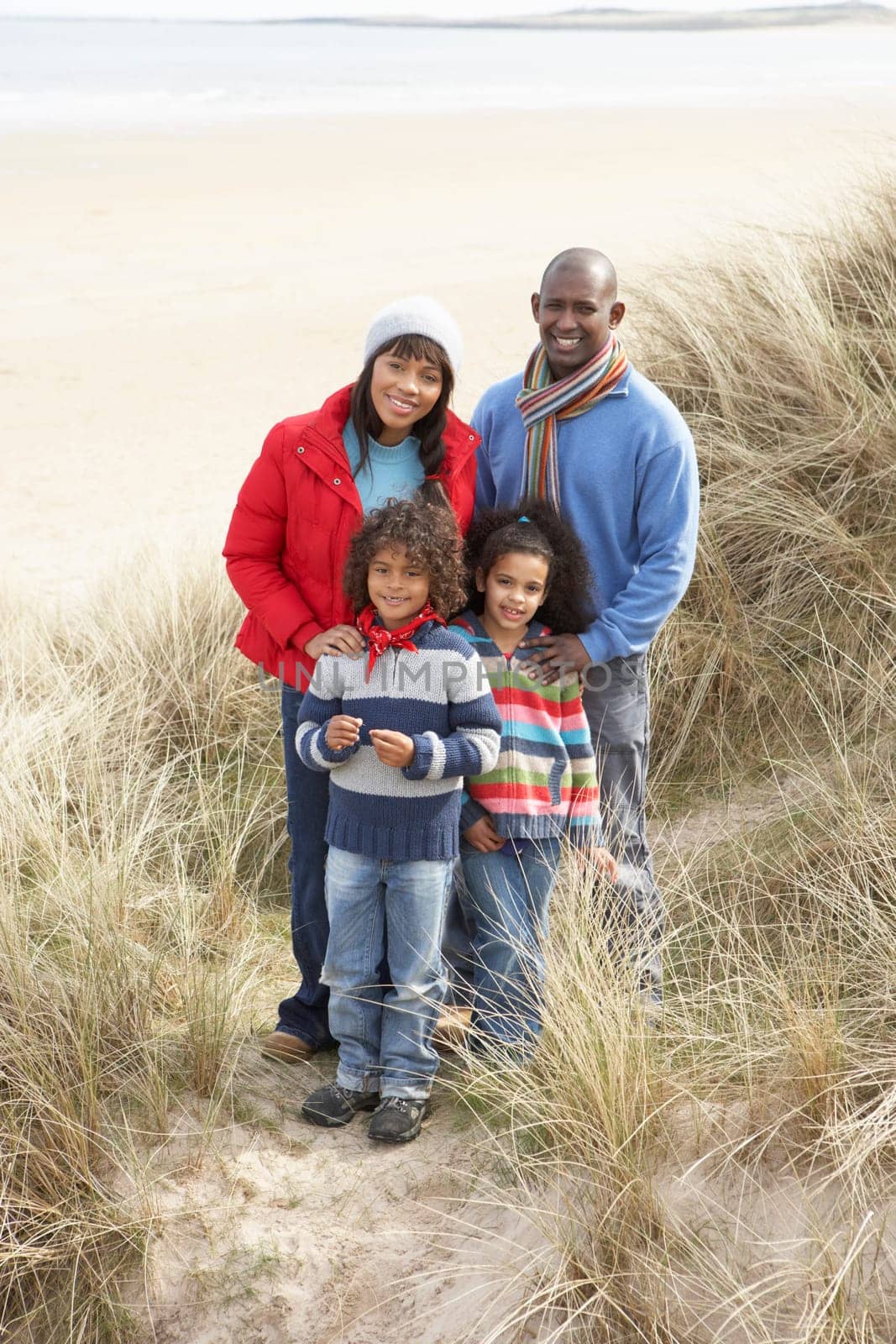 Family Walking In Dunes On Winter Beach