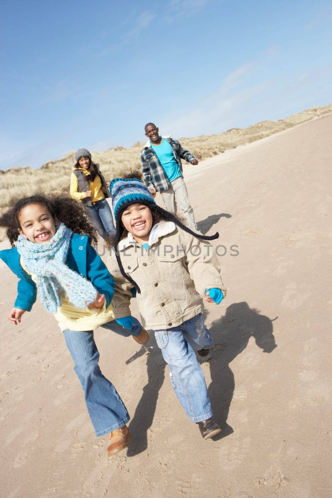 Family Running On Winter Beach