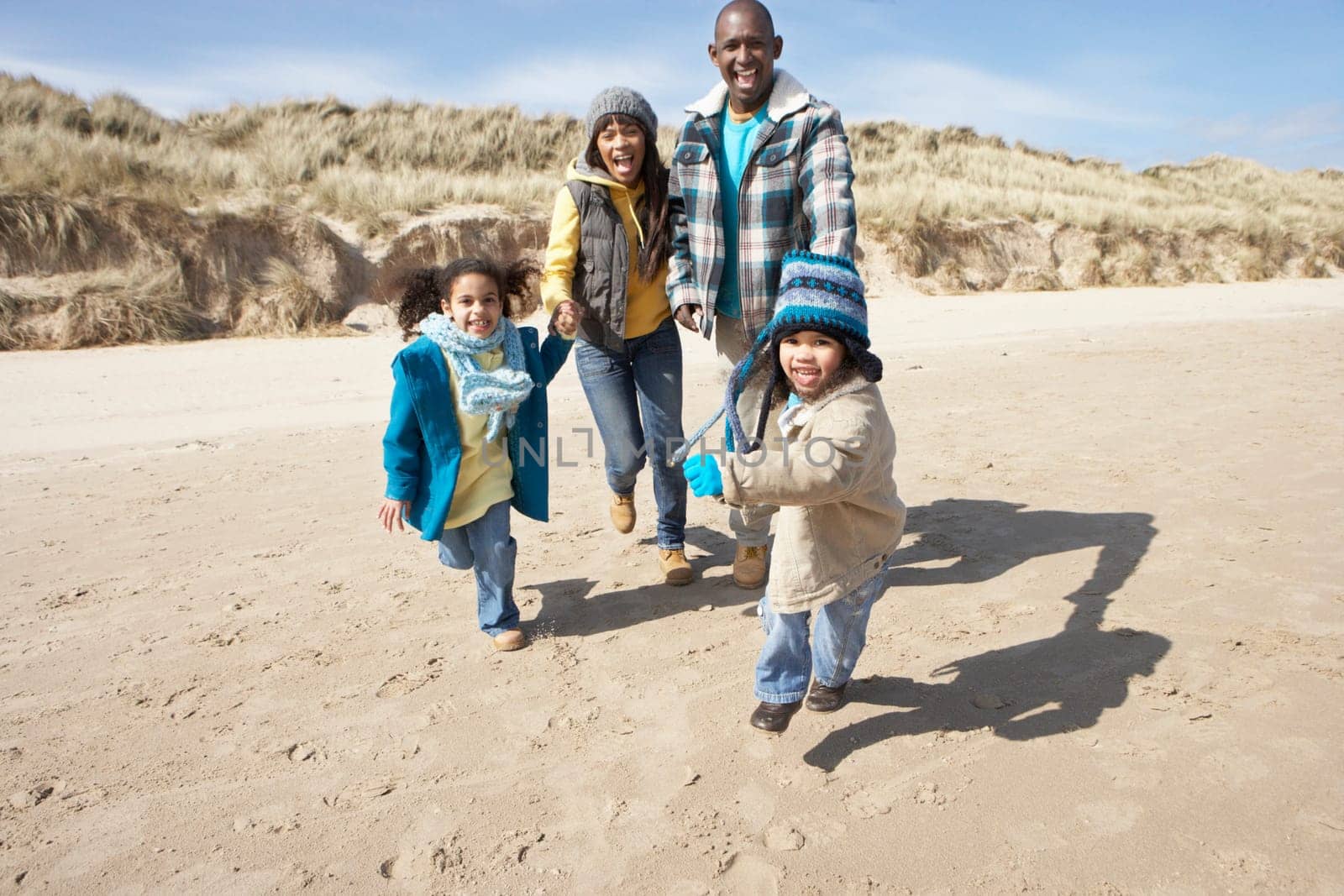 Family Running On Winter Beach