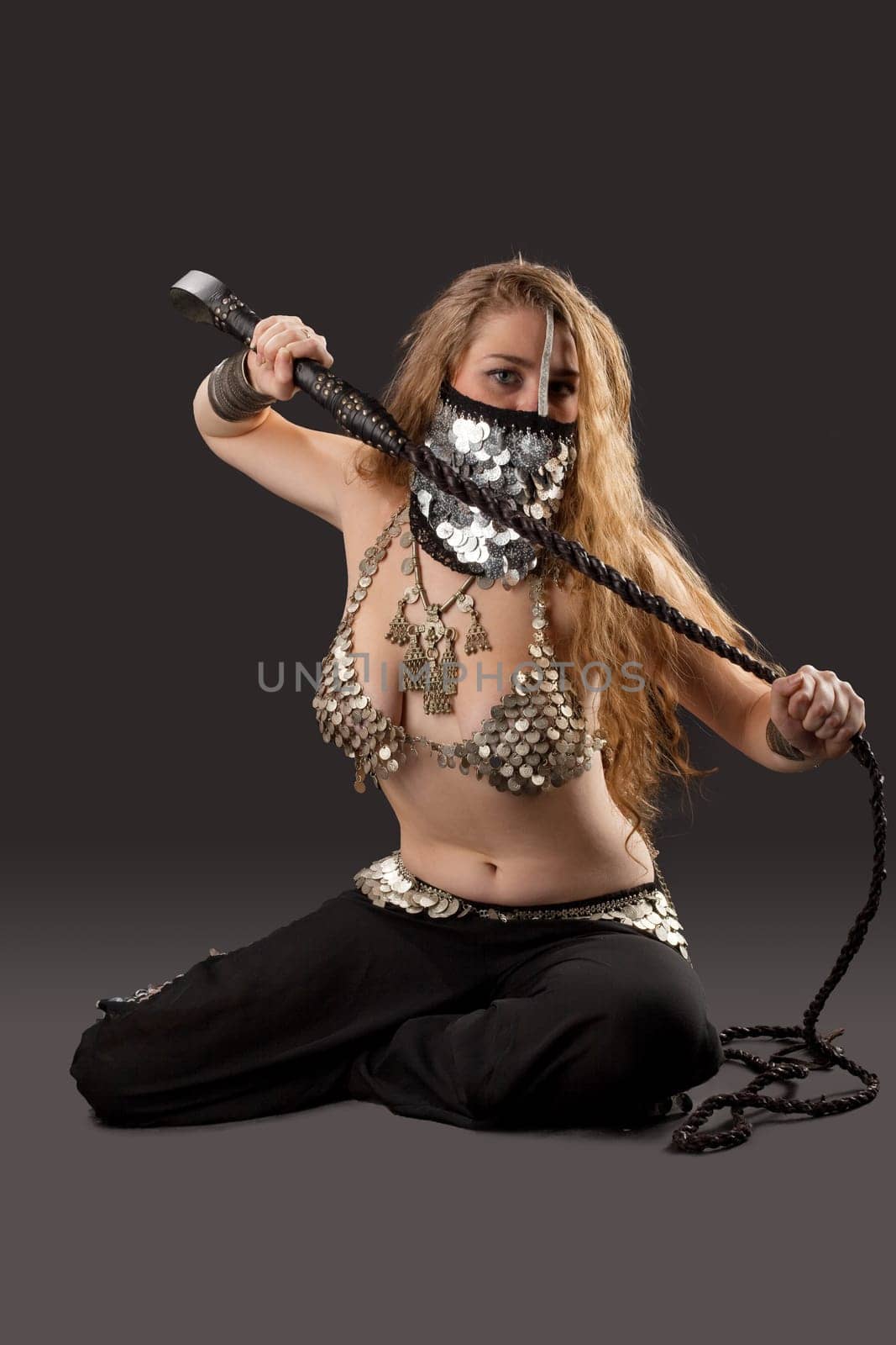 Young Woman dance with knout in chain mail on breast- traditional arabia costume