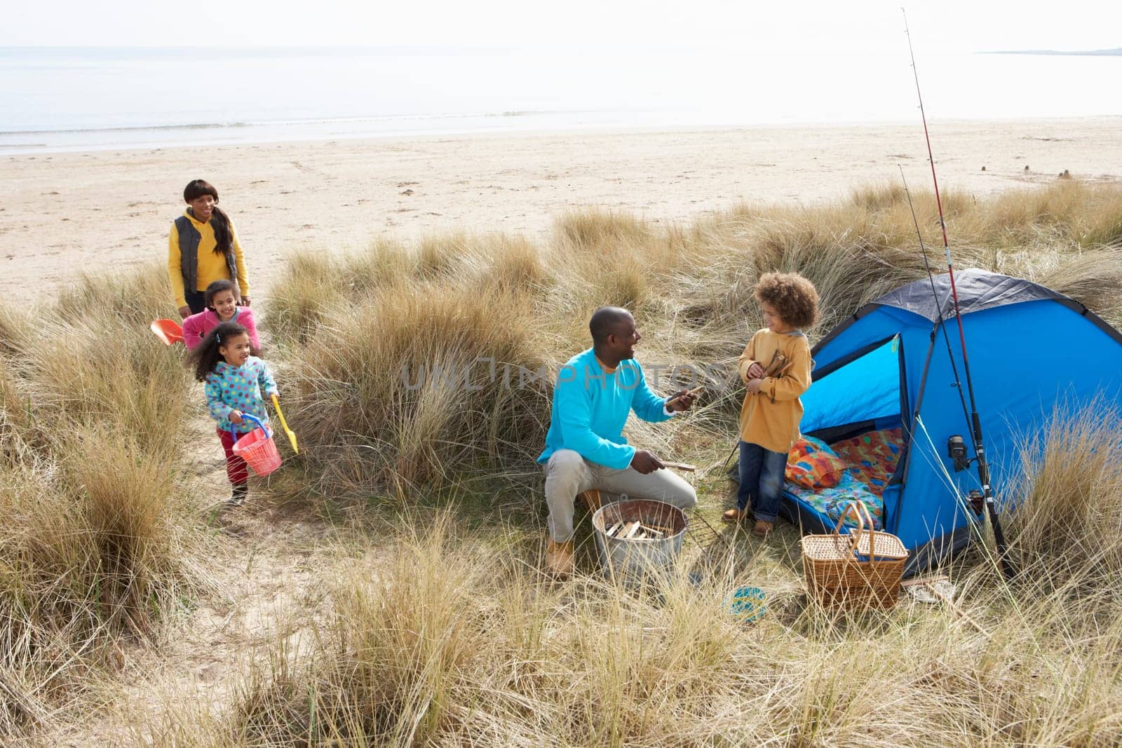 Young Family Relaxing On Beach Camping Holiday