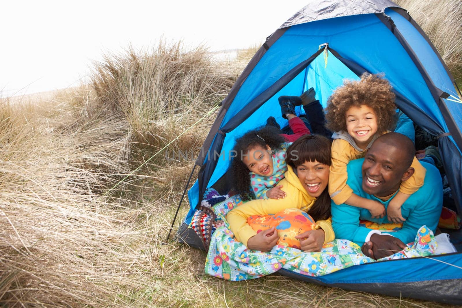 Young Family Relaxing Inside Tent On Camping Holiday