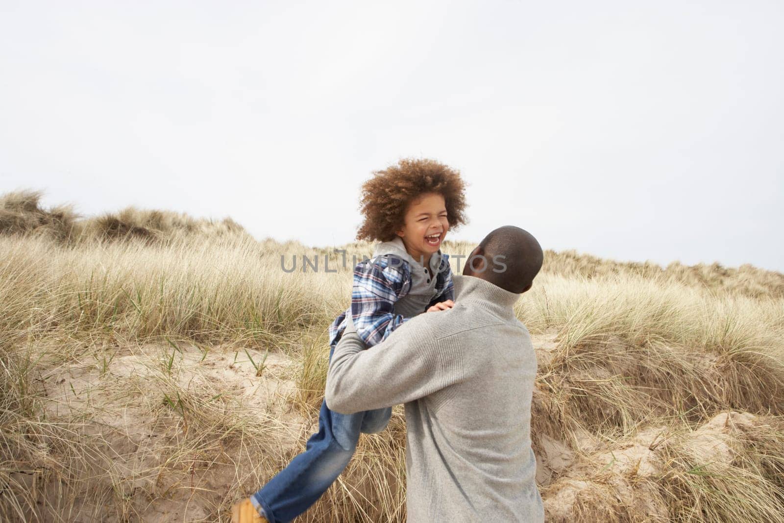 Father And Son Having Fun In Sand Dunes