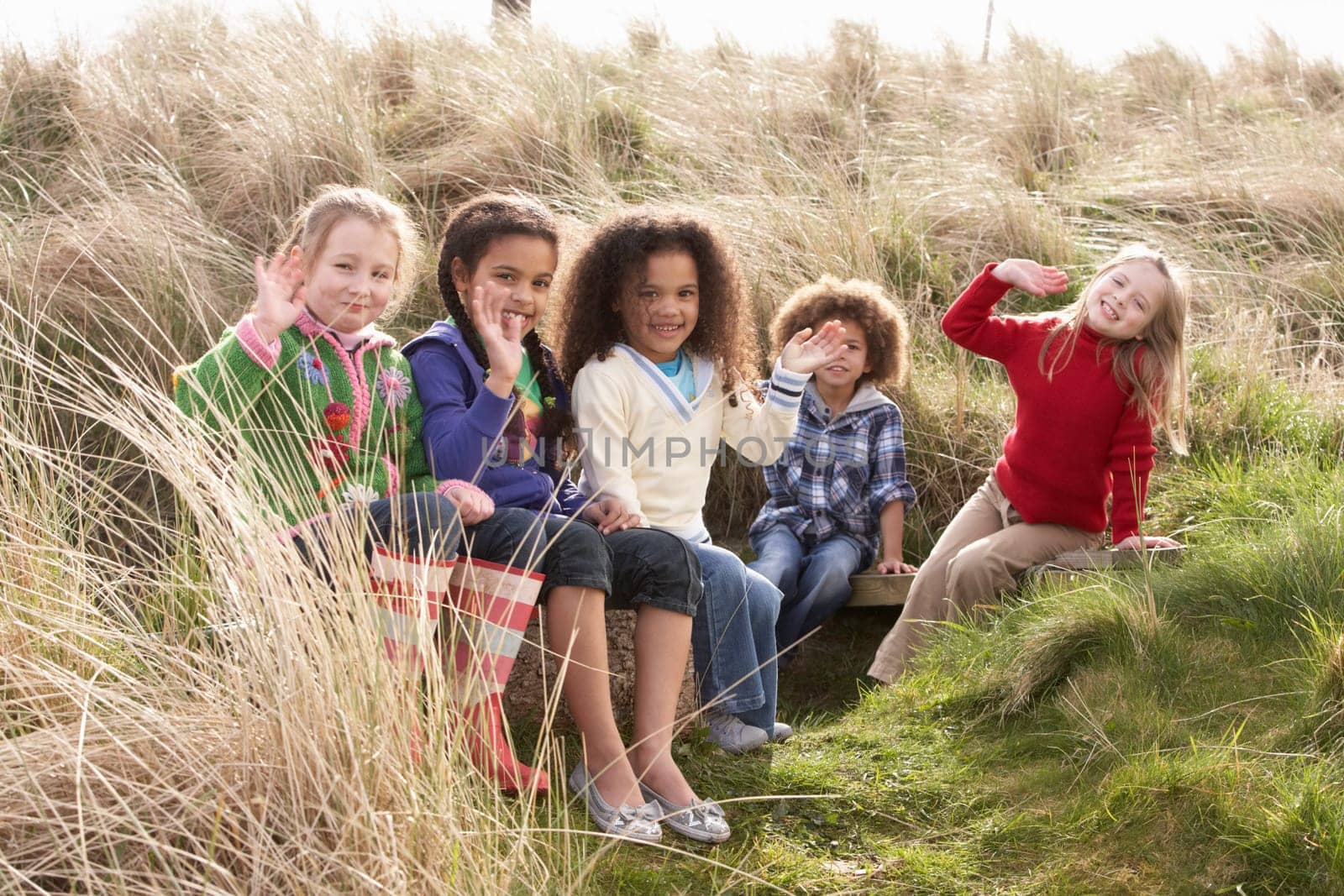 Group Of Children Playing In Field Together