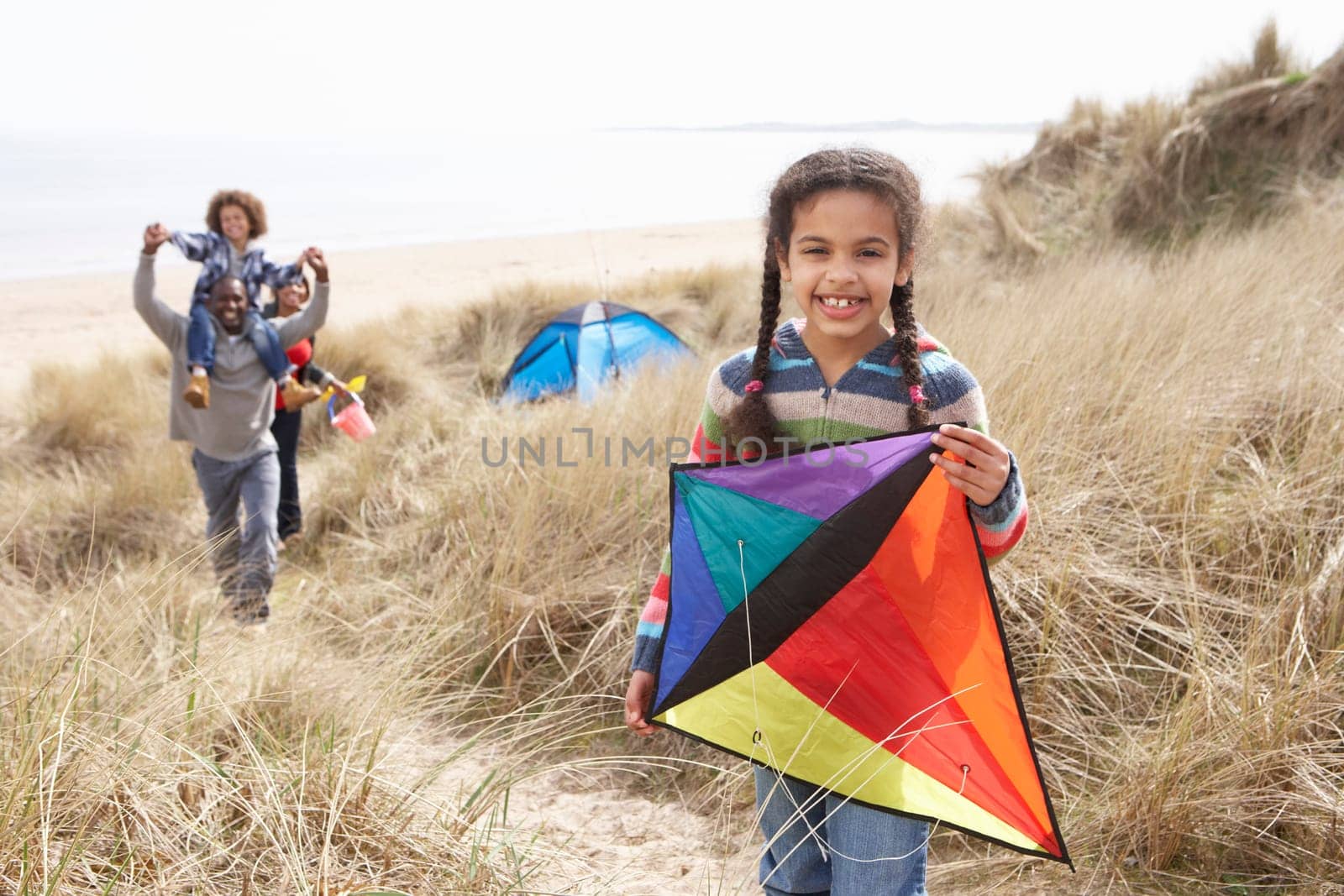 Family Having Fun With Kite In Sand Dunes