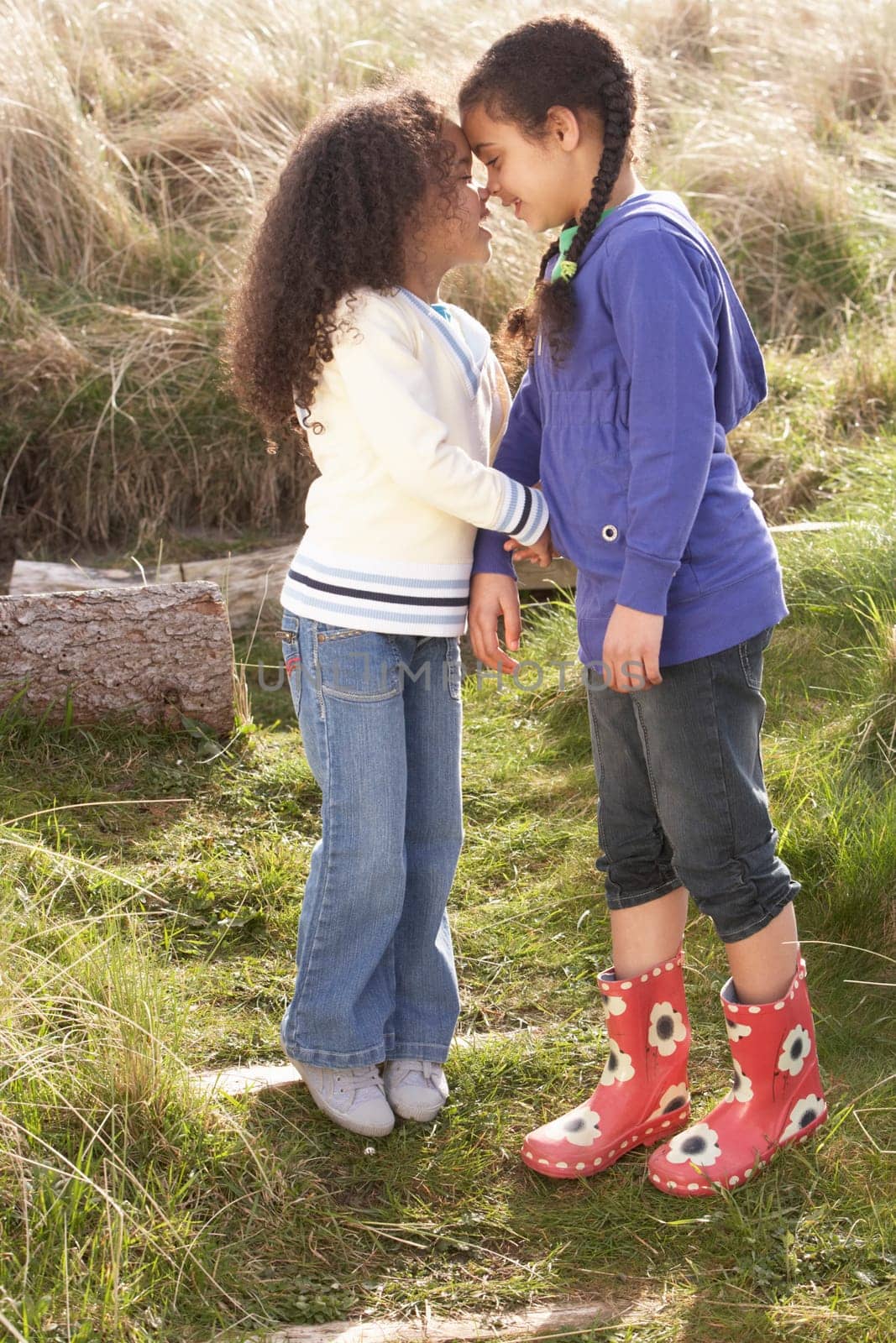 Young Girls Playing In Field Together