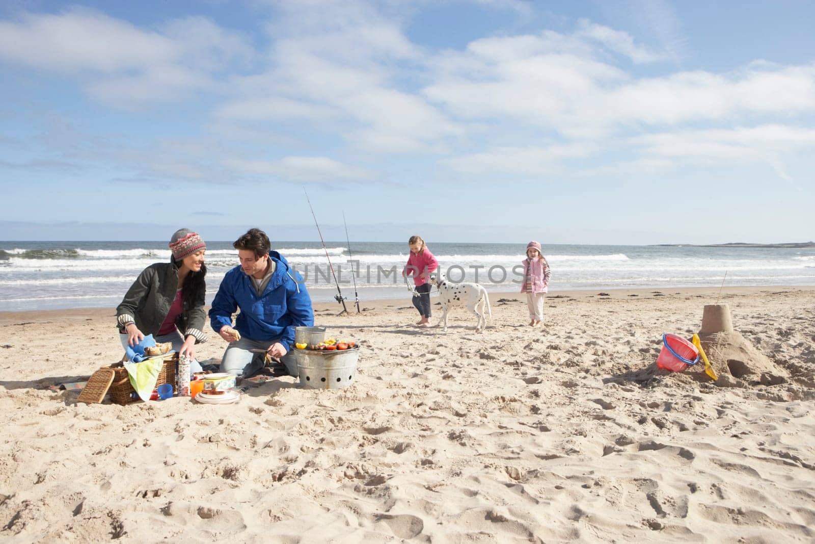 Family Having Barbeque On Winter Beach