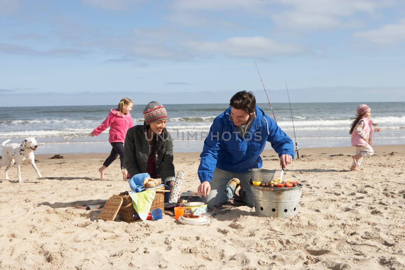 Family Having Barbeque On Winter Beach
