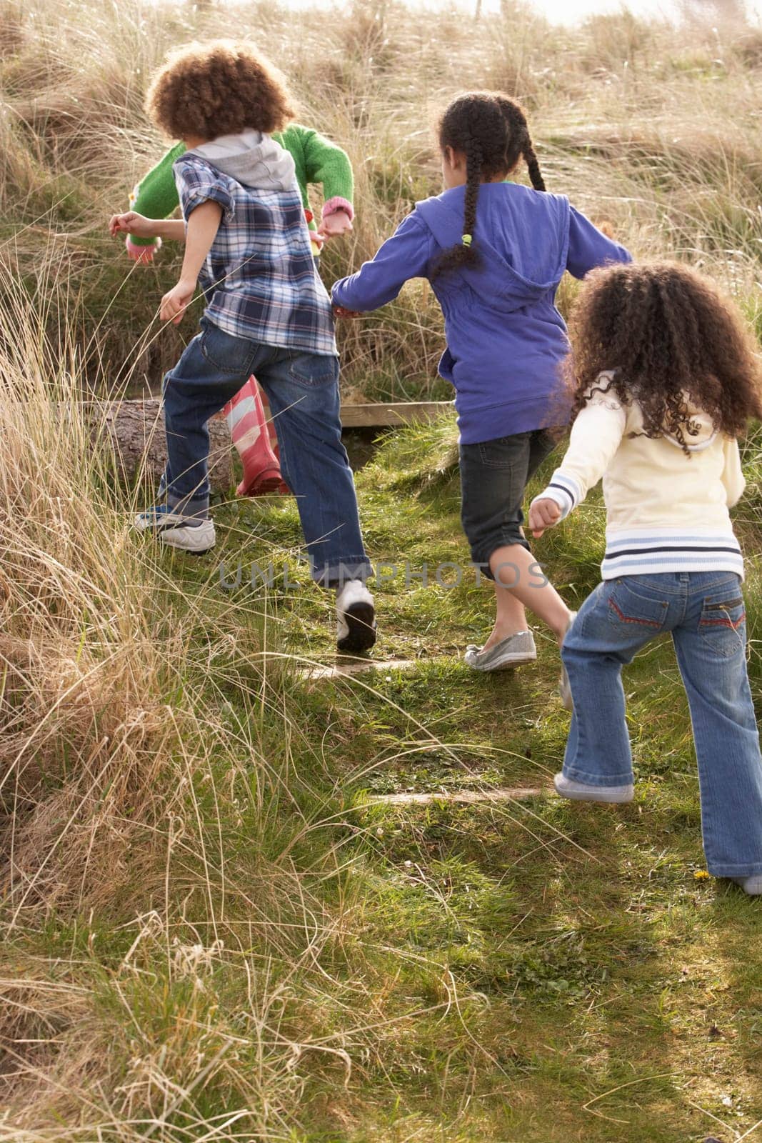 Group Of Children Playing In Field Together