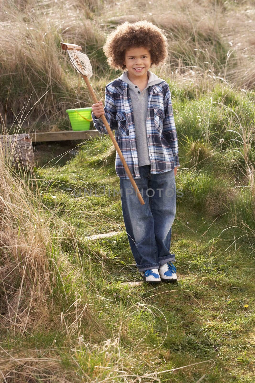 Young Boy Carrying Fishing Net At Seaside