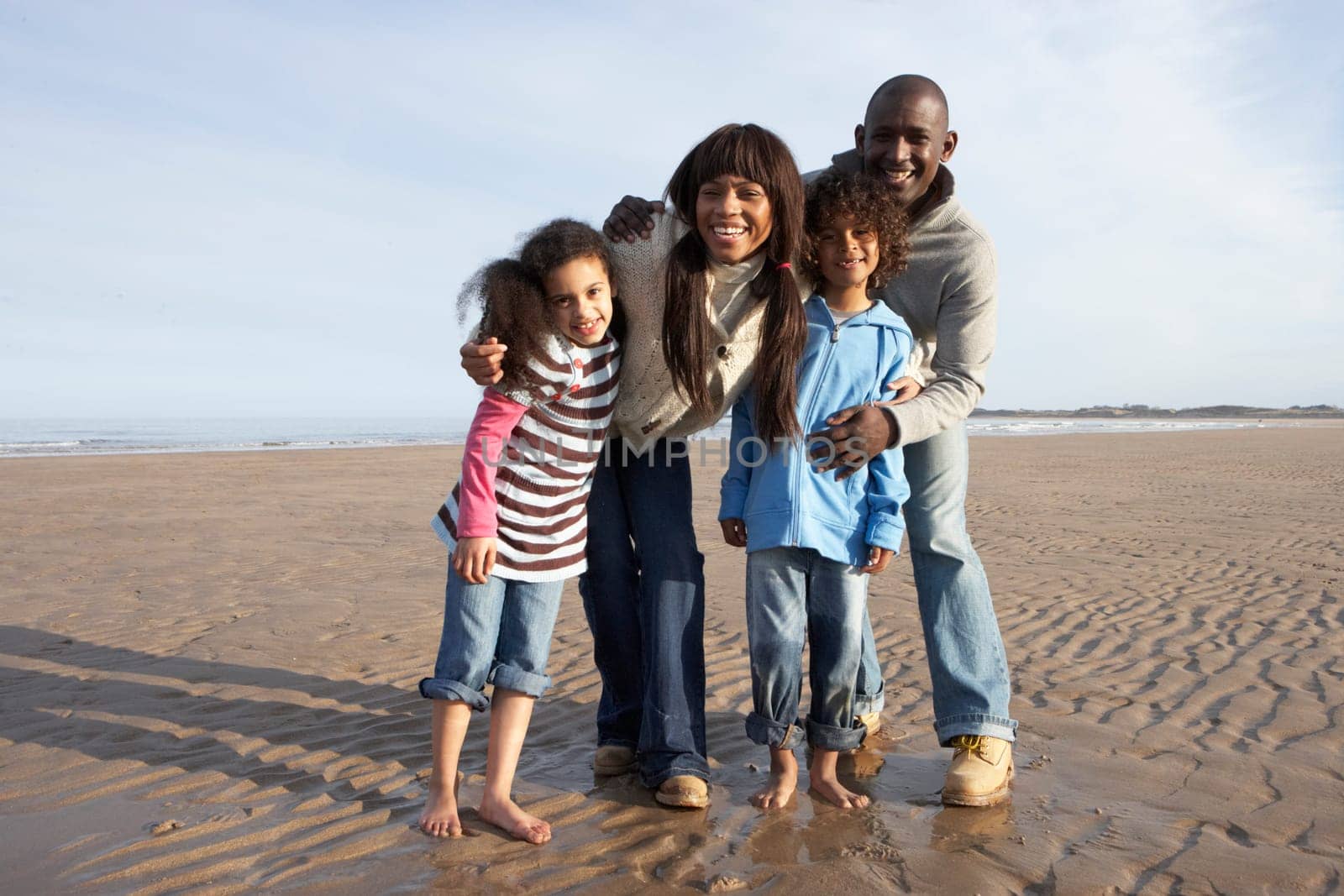 Family Walking On Winter Beach