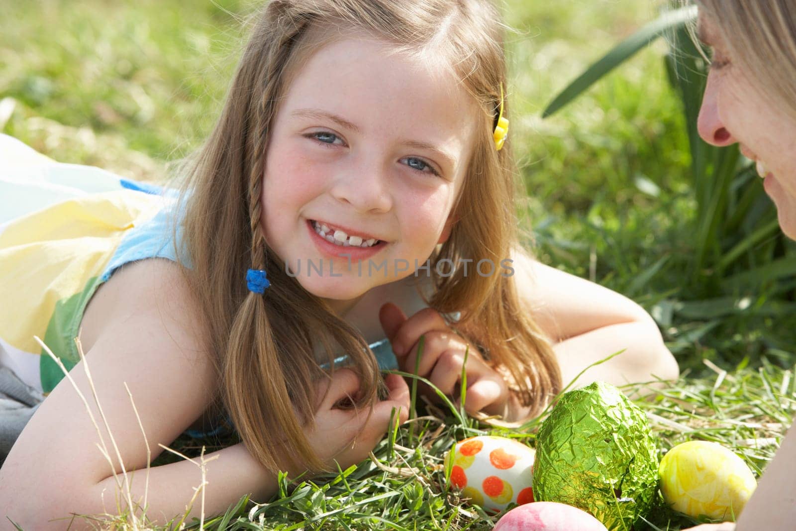 Mother And Daughter On Easter Egg Hunt In Daffodil Field