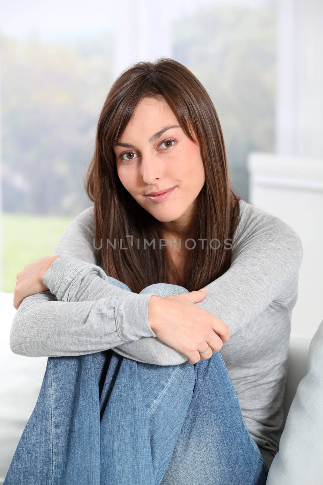 Beautiful woman sitting on sofa at home