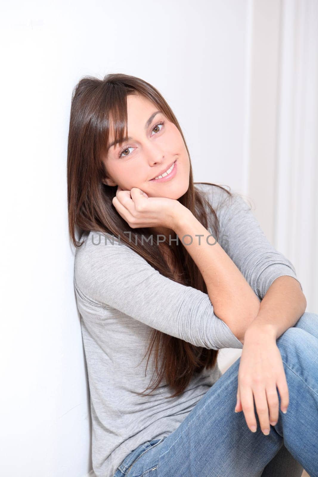 Beautiful young woman sitting on the floor