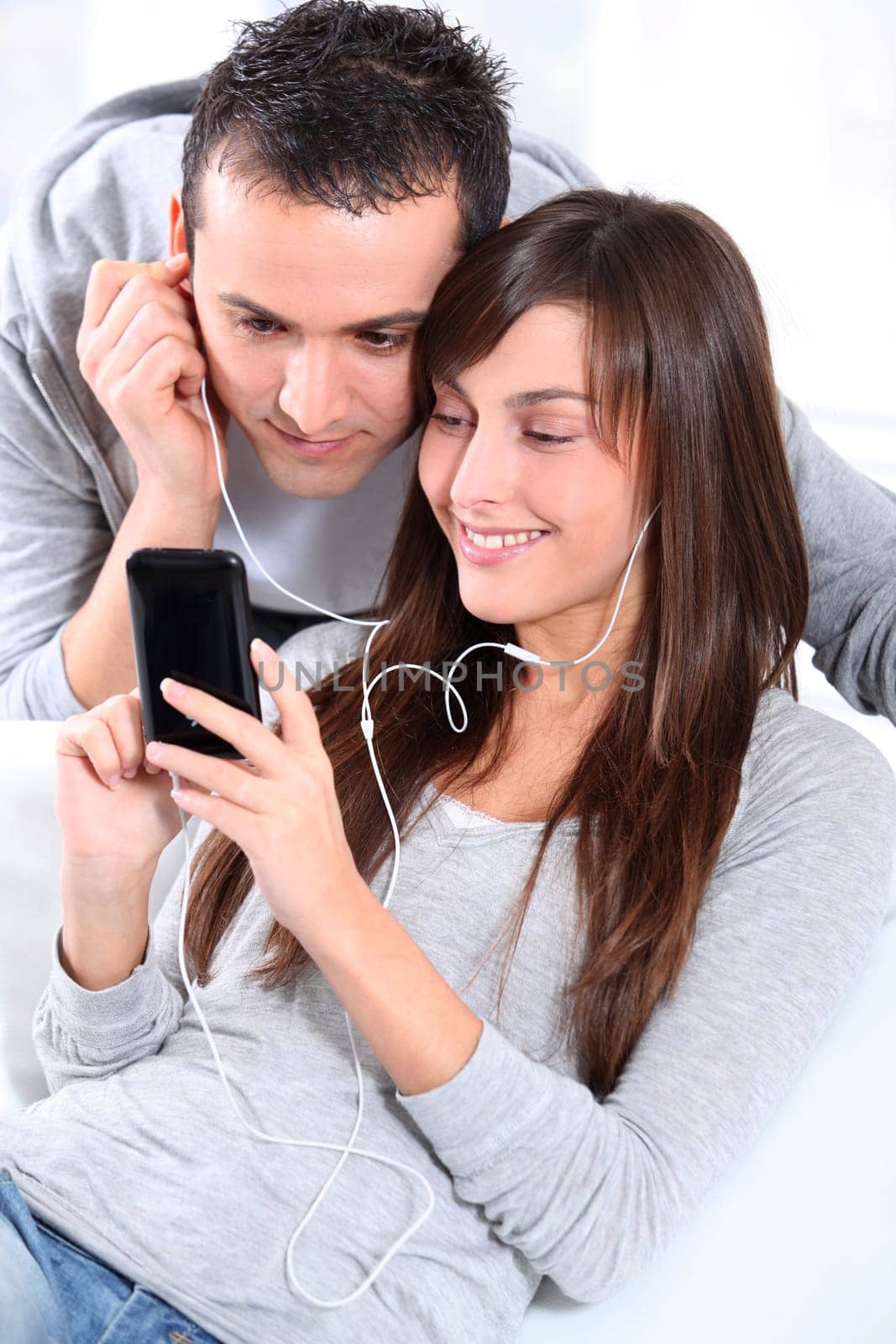 Young couple listening to music with mobile phone