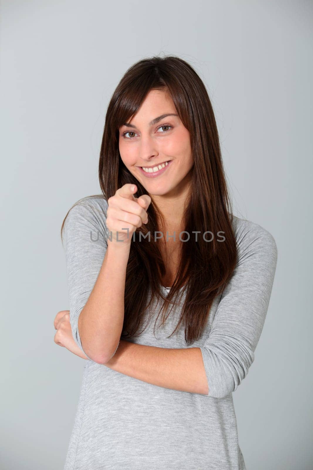Young woman pointing at with finger