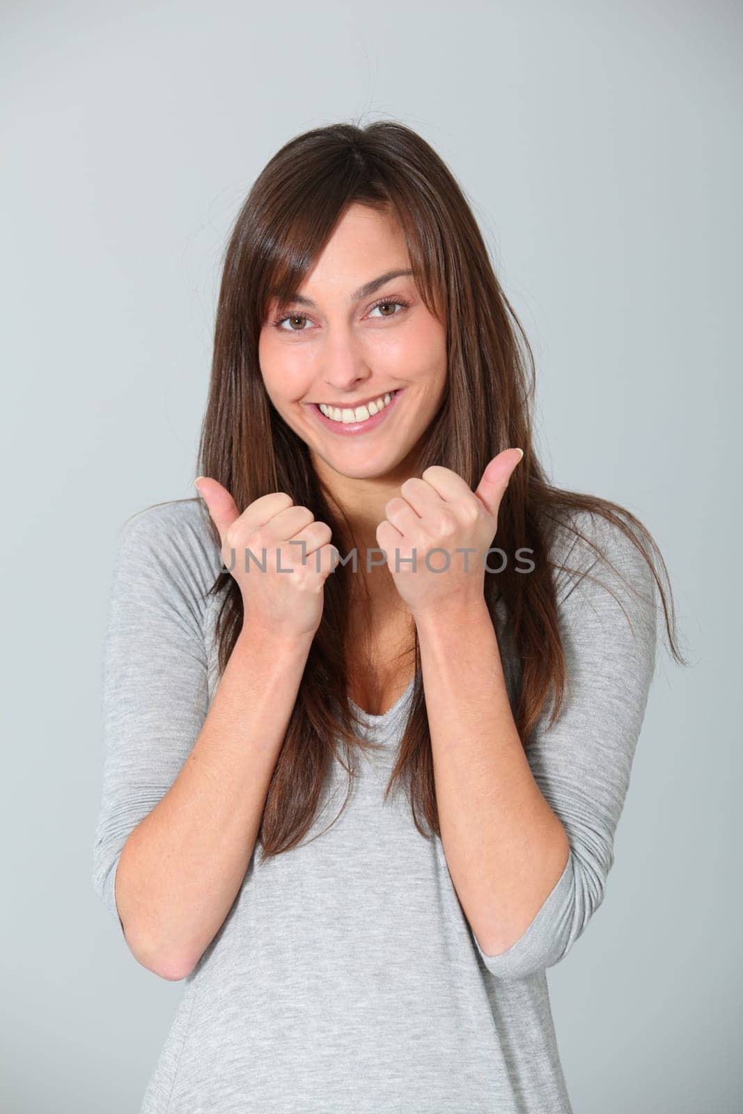 Smiling young woman with thumbs up