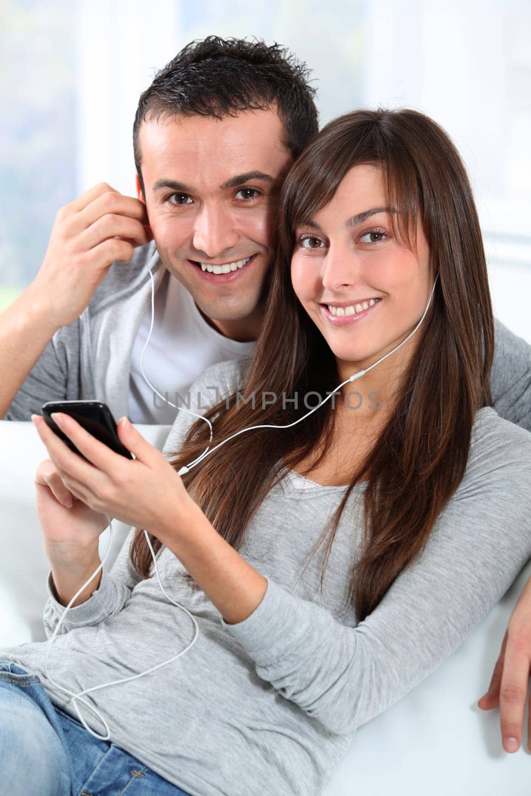 Young couple listening to music with mobile phone