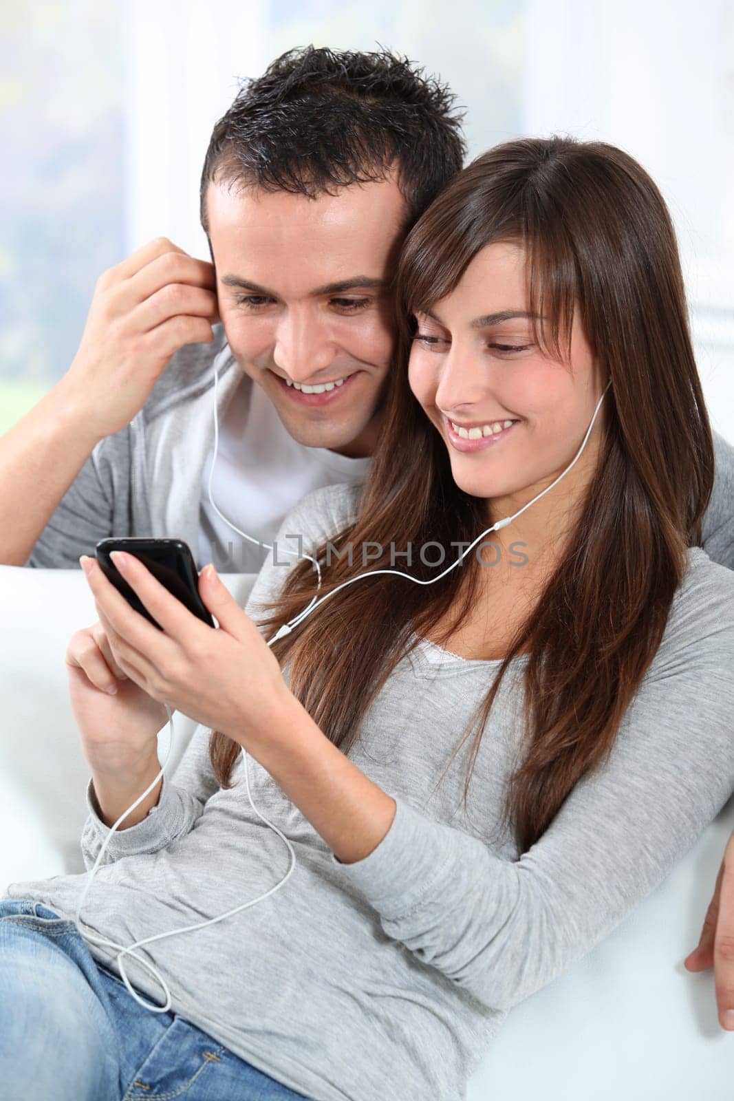 Young couple listening to music with mobile phone