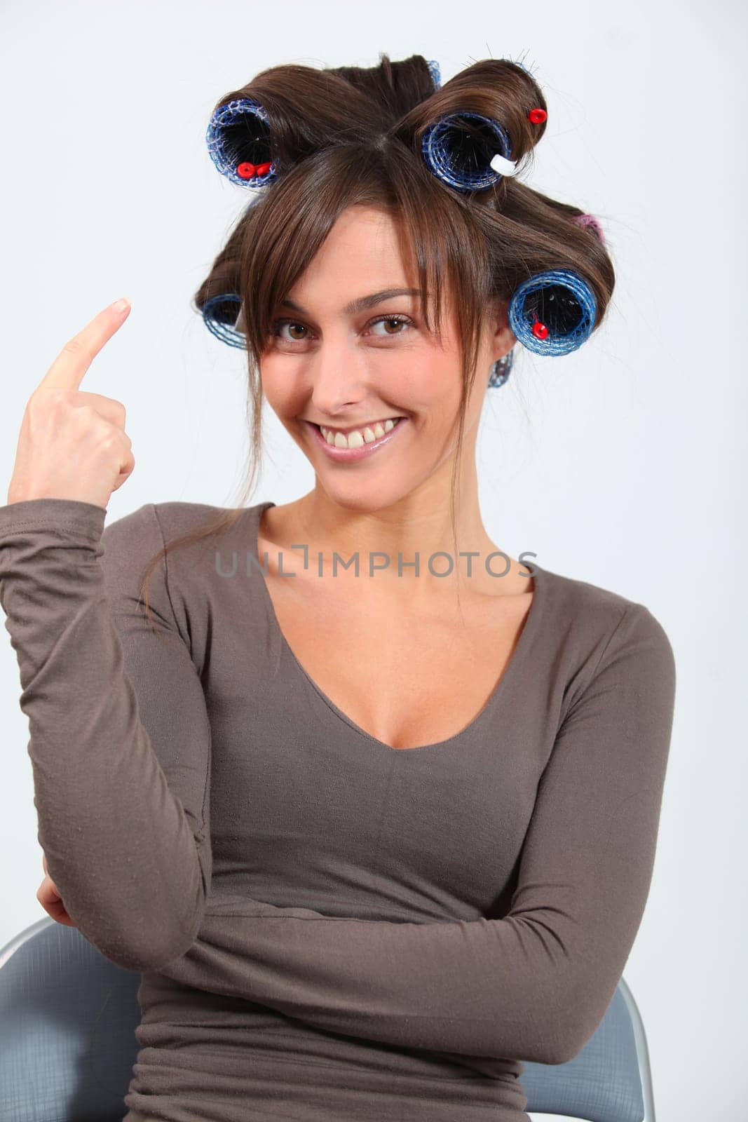 Beautiful woman with hair-curlers doing funny faces