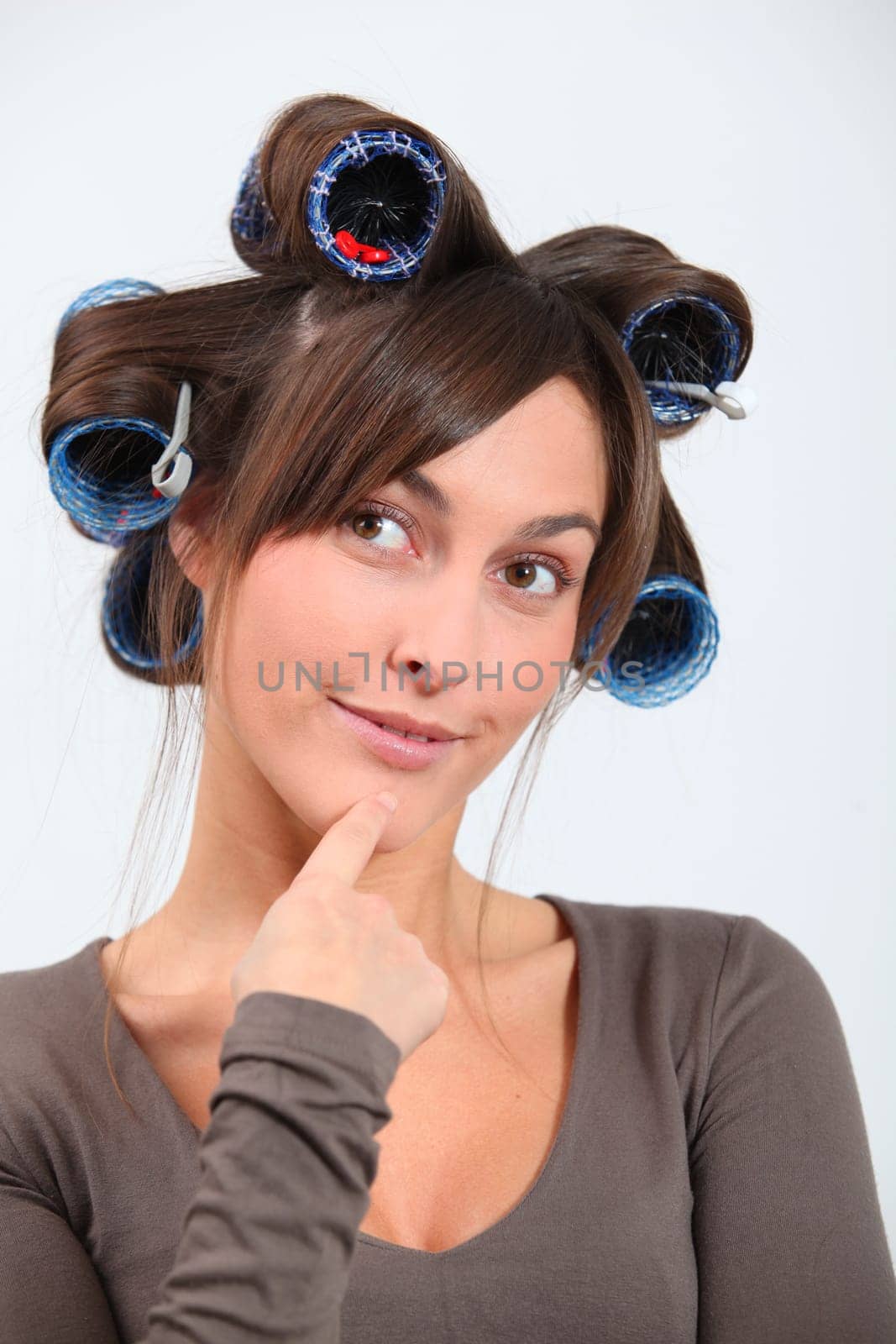 Beautiful woman with hair-curlers doing funny faces