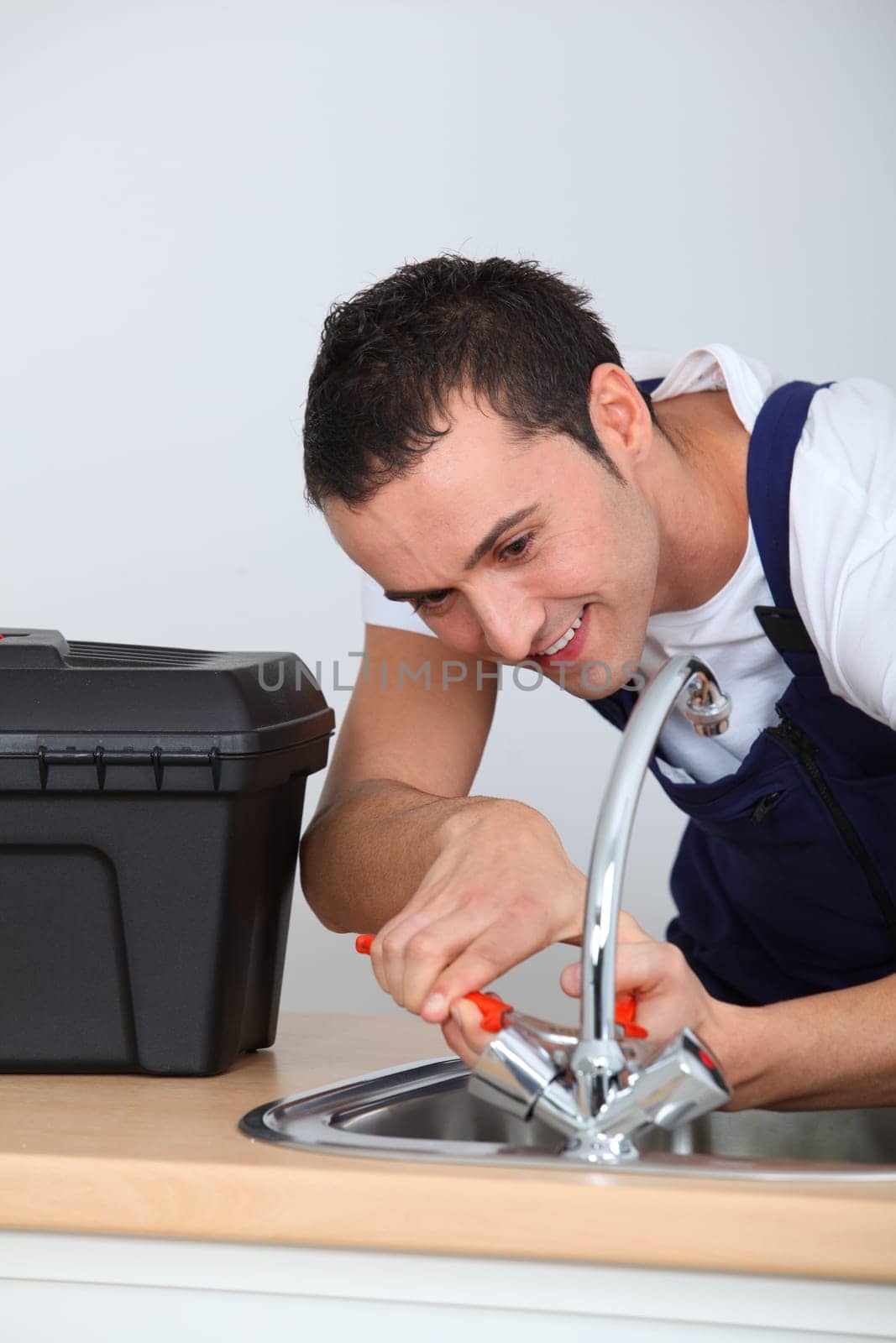 Young man fixing sink