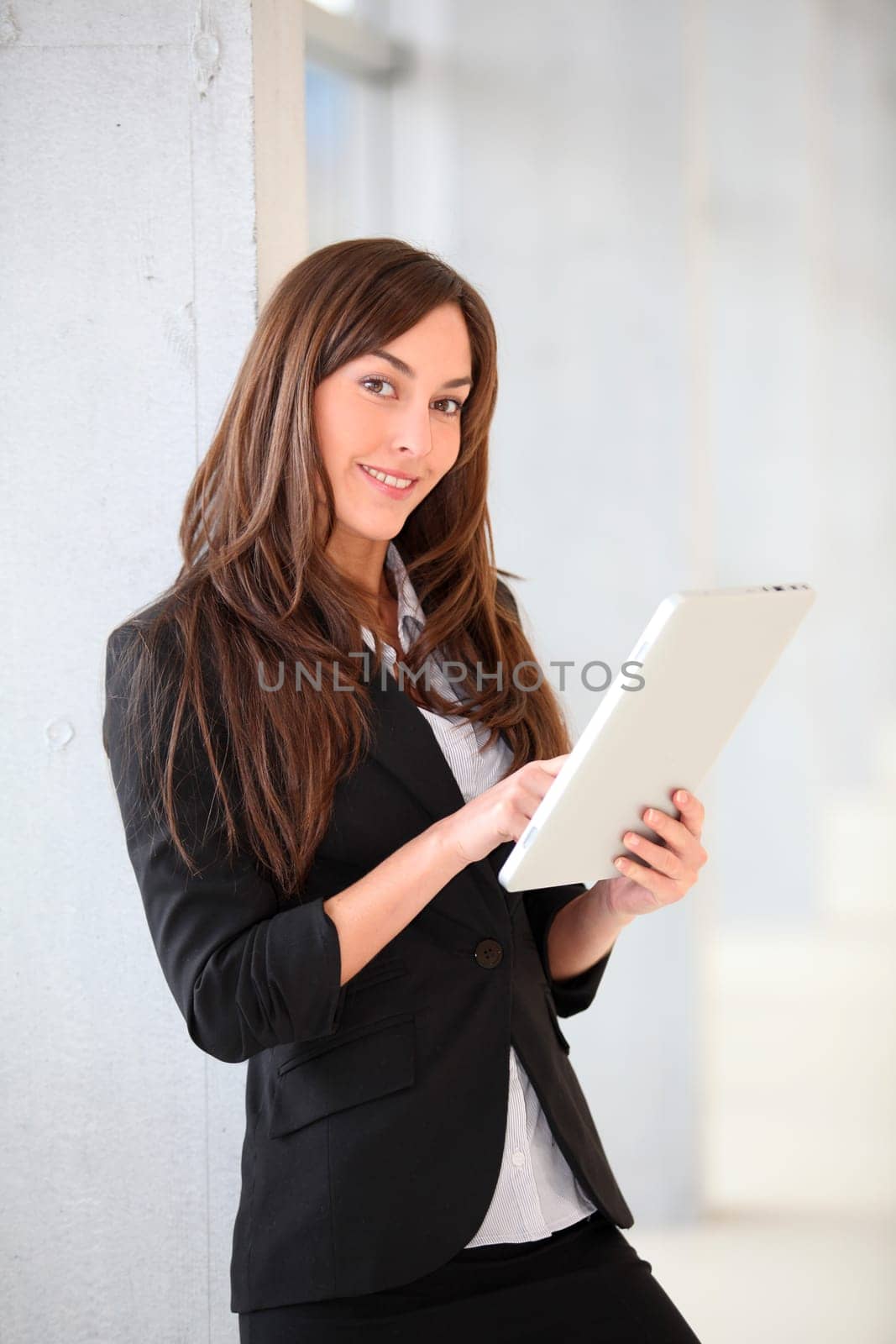 Businesswoman standing in hall with electronic pad