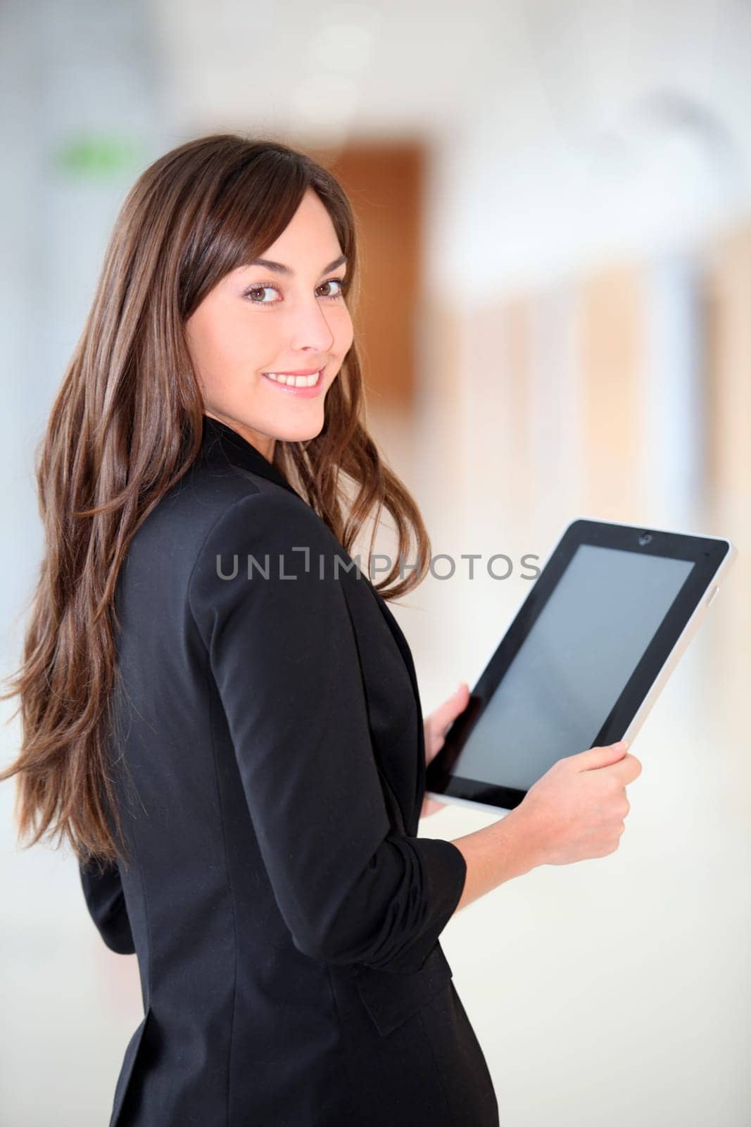 Businesswoman standing in hall with electronic pad