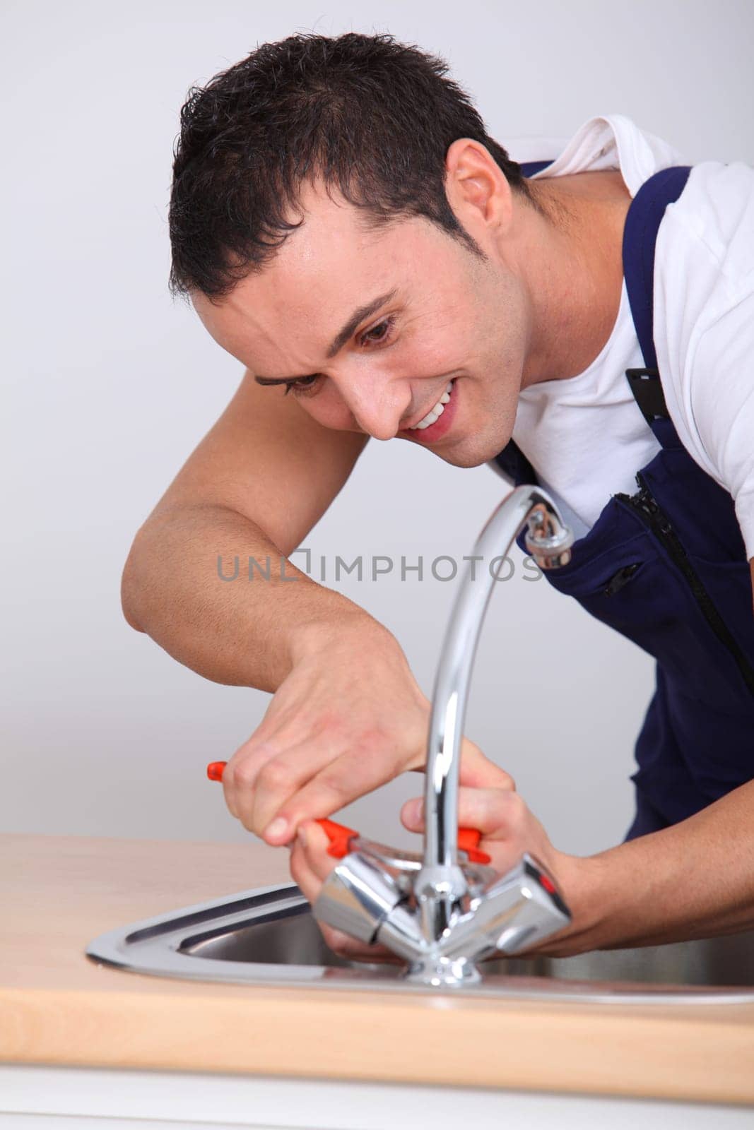 Young man fixing sink