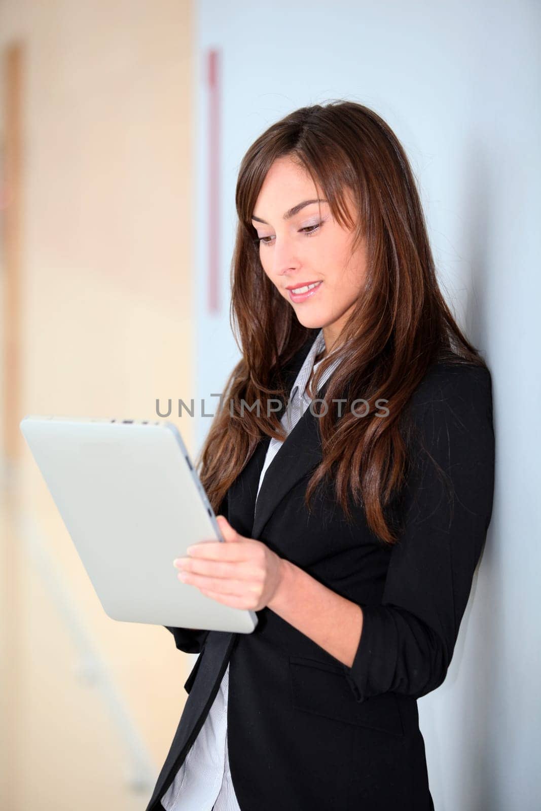 Businesswoman standing in hall with electronic pad