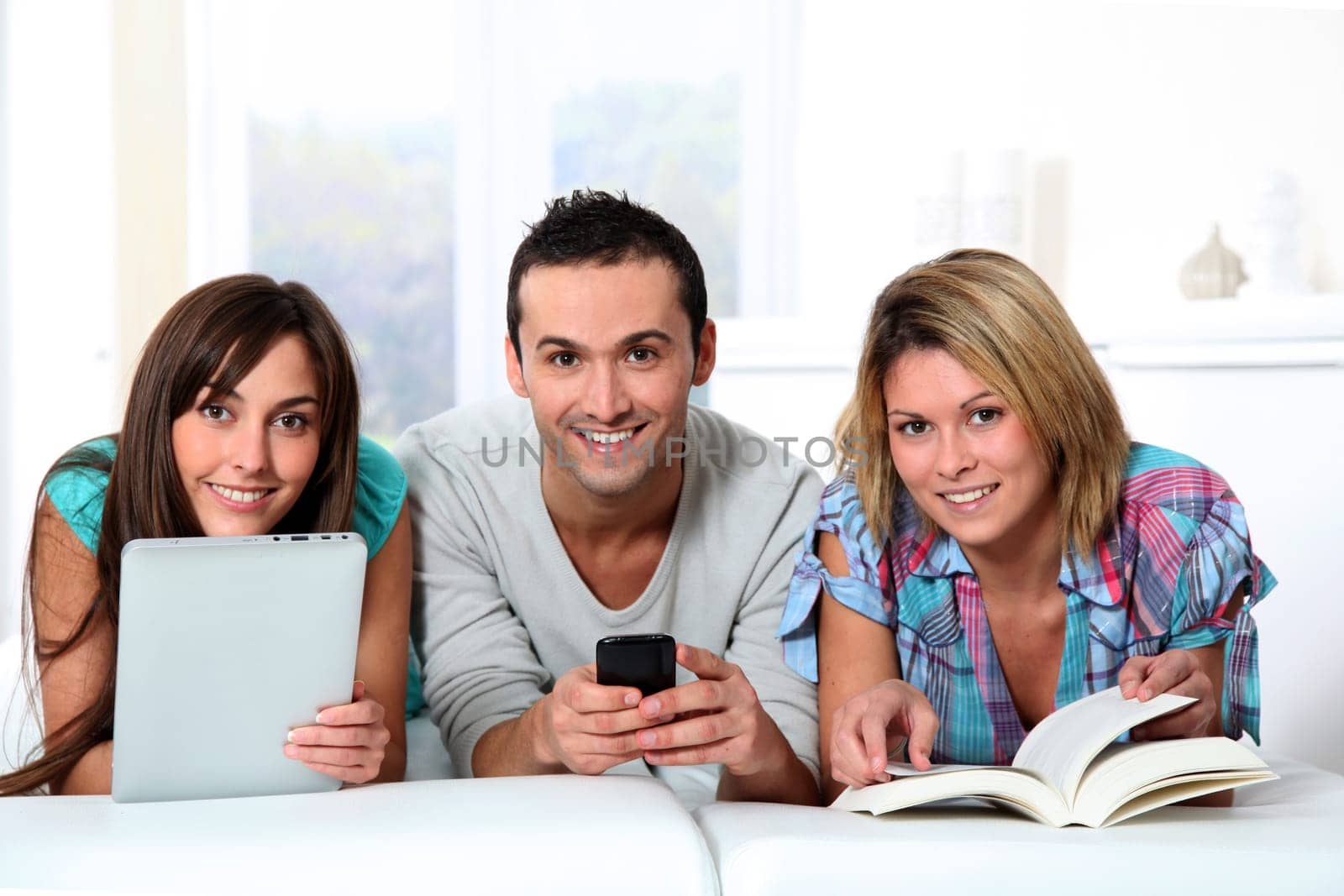 Group of friends laying in sofa at home
